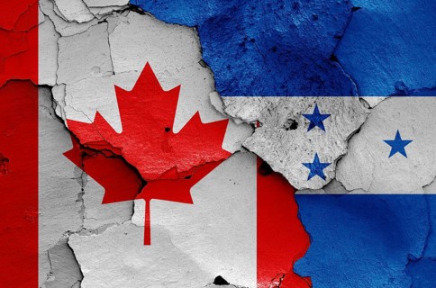 Flags of Canada and Honduras painted on cracked wall