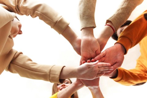 Pile of hands of friends. Teenagers putting their hands together. Close up