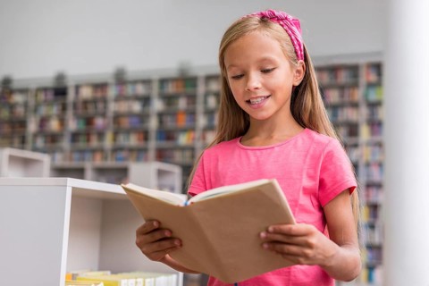 Little girl reading book library