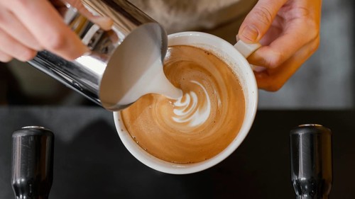 Top view male barista pouring milk coffee cups