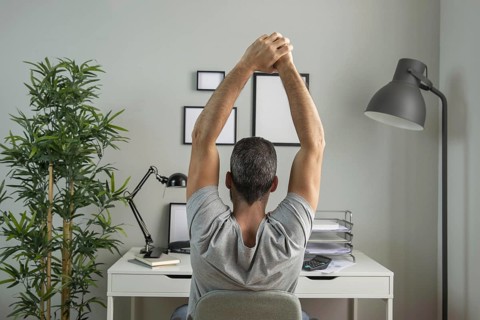 Back view man desk stretching while working from home. Resolution and high quality beautiful photo