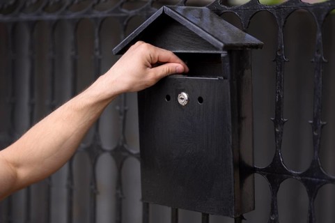 Close up hand touching mailbox