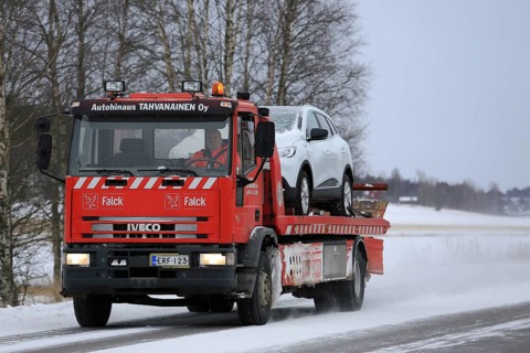 SALO, FINLAND, JANUARY 7, 2017: Red Iveco tow truck tows a car along road on a cold day in winter.