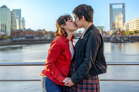 Young LGBT couple of women holding hands and sharing a kiss