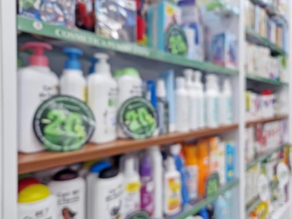 Defocus background with stocked shelves on sale inside the drugstore. 20% discount on cosmetics and