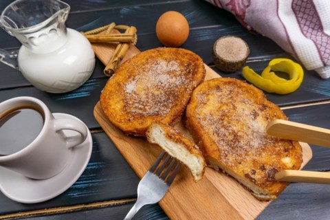 Top view of some torrijas with coffee, milk and elements for its elaboration