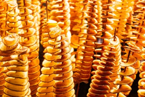 Spiralised potatoes on a wooden skewer at the Mercado de la Boqueria in Barcelona, Spain, Europe