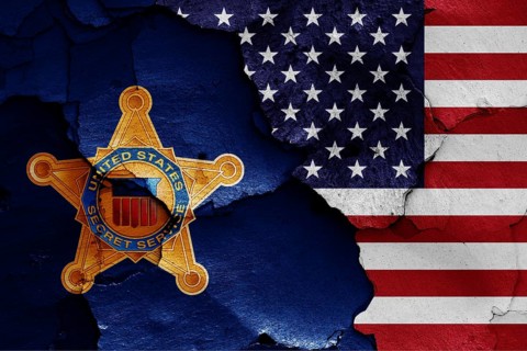 Flags of United States Secret Service and USA painted on cracked wall