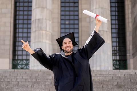 Confident man in graduation outfit, male obtaining degree, academic career