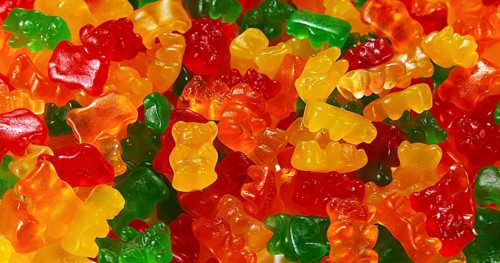 Gold Bears or Gummy Bears falling against White Background