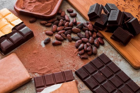 Overhead view chocolate bars with cocoa powder raw beans