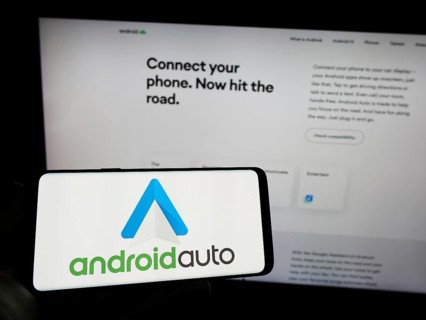 Stuttgart, Germany, 03-14-2023: Person holding mobile phone with logo of mobile app Android Auto