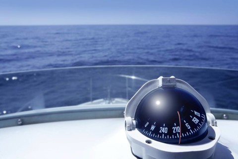 Compass on a yacht boat tower on a blue summer sea ocean day