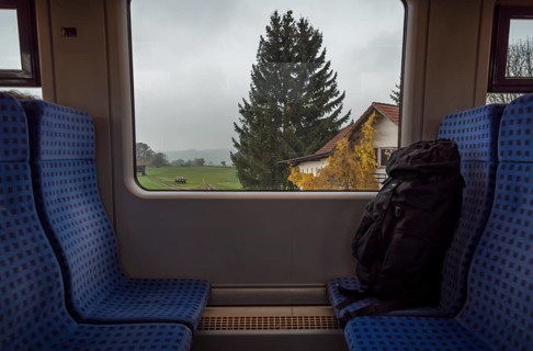 German train interior with a rucksack on the seats and a bavarian landscape view on the window