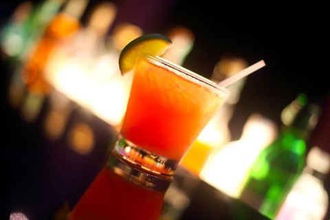 Tequila sunrise cocktail on night bar background