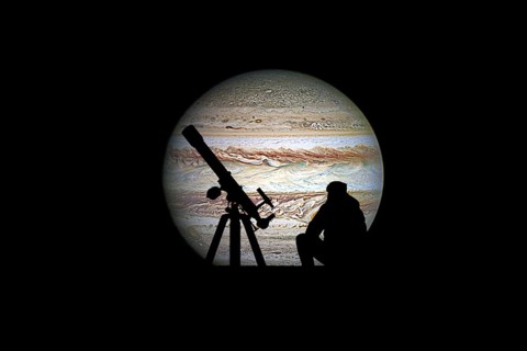 Man with telescope looking at the stars. Jupiter planet, isolated on black. Elements of this image
