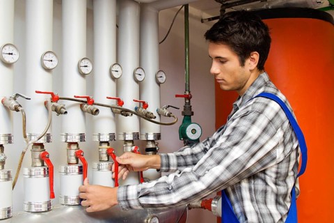 Young heating technician maintains a heating system, Austria, Europe