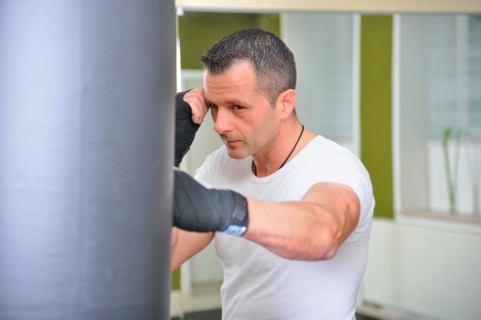 Boxers trained on a punching bag. Man trains on a punching bag