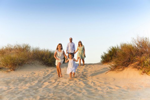 Happy family of four, young parents and little kids, enjoying summer vacation in nature, taking