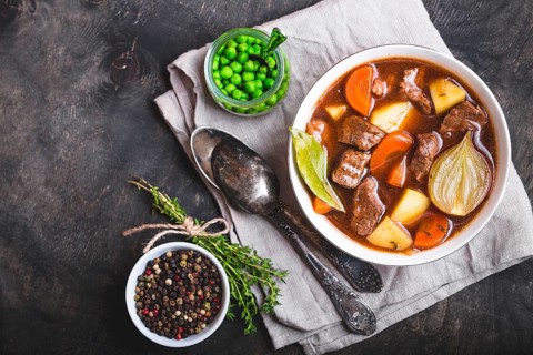Meat stew with beef, potato, carrot, onion, spices. green peas. Slow cooked meat stew in bowl,
