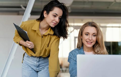 Women checking work project together