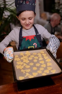 Girl in cooking apron baking Christmas biscuits