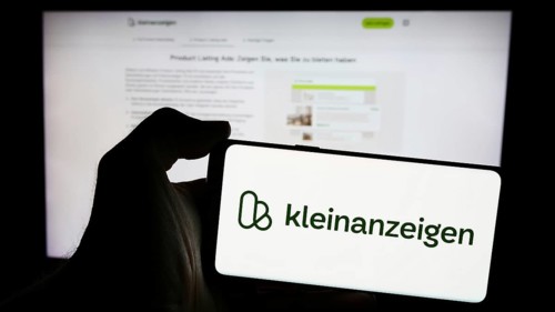 Stuttgart, Germany, 04-13-2024: Person holding mobile phone with logo of German classifieds