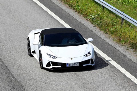 White Lamborghini Huracán LP 580-2 Spyder supercar at speed on motorway E18, elevated view. Salo,