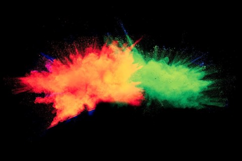 Abstract color powder explosion on black background.Freeze motion of dust splash. Painted Holi in