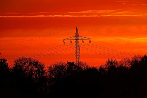 High-voltage pylon, electricity pylon with high-voltage lines at sunset, Bad Wünnenberg, North