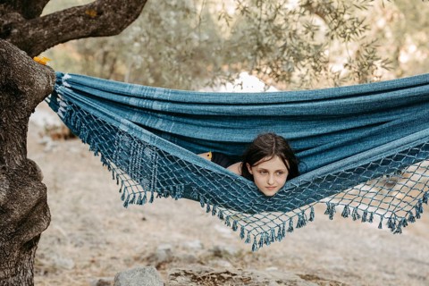 Girl lying in a hammock stretched between two trees