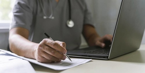 Side view doctor with stethoscope working laptop writing paper, Resolution and high quality