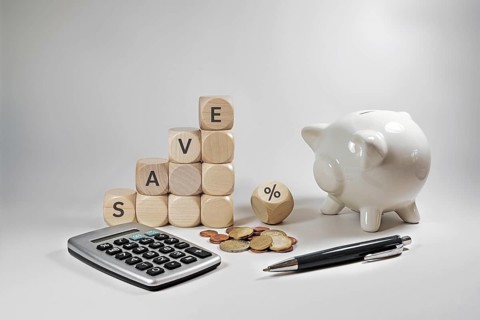 Home finance concept during inflation, wooden cubes with the word save and a percent sign, piggy