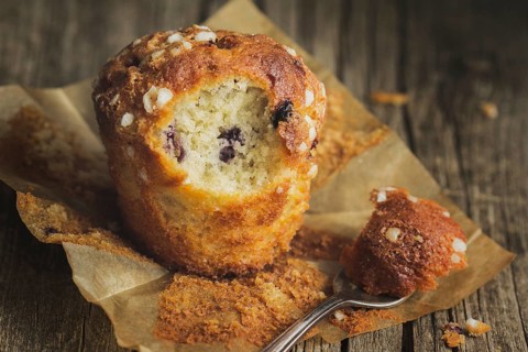 Blueberry muffin on baking paper with fork