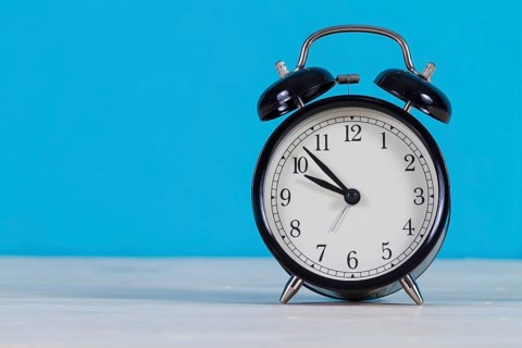 Close up alarm clock with blue background