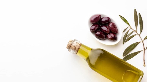 Olive oil bottle with leaves purple olives with copy space