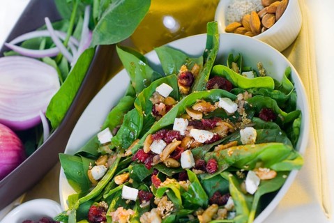 Plate of fresh colorfull spinach salad close up