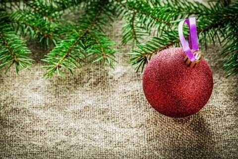 Pine tree branch Christmas bauble on sacking background