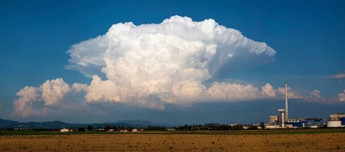 A storm cloud (Cumulonimbus) formed into an anvil over the Bavarian forest, Südzucker factory,