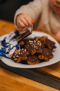 A child reaching for baked gingerbread cookies because of Christmas. Christmas vibe. Cookies with