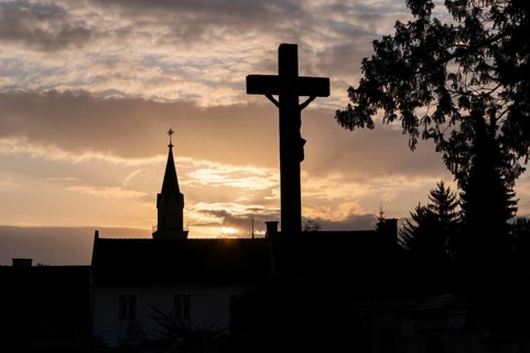 Sunset, silhouette of a cross and a church tower, Jakobifriedhof, Leoben, Styria, Austria, Europe