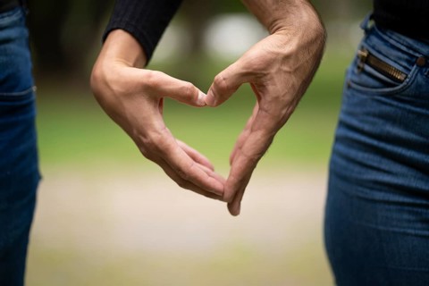 Couple holding hands making a heart