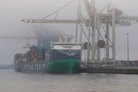 Weather, heavy fog in winter, container gantry cranes and container ship CMA CGM Ermitage of the
