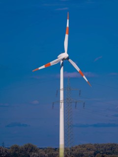 Wind turbine and high-voltage pylon with power lines at the Schacht Konrad wind farm, Salzgitter,