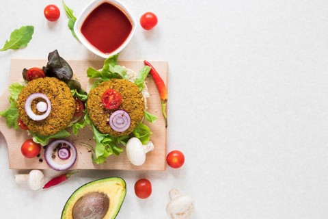 Flat lay vegan burgers wooden board with copy space