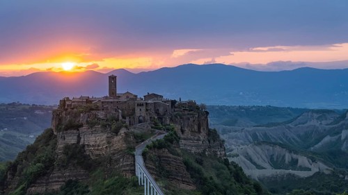 The mountain village of Civita di Bagnoregio in hilly landscape at sunrise, Civita di Bagnoregio,