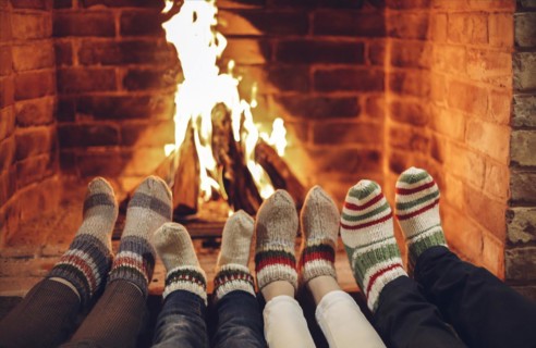 Family wearing warm woolen socks resting by fireplace at home on Christmas time, cropped. Mother,