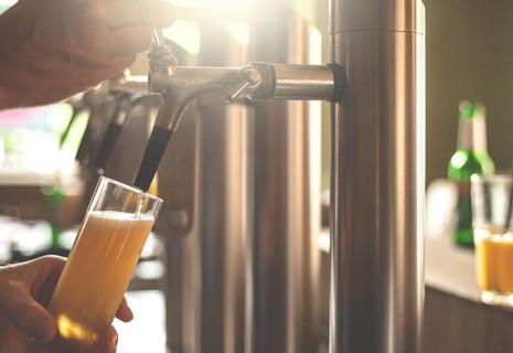 A landlord taps beer in a bar
