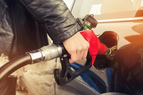 Hipster woman in sunglasses fills gasoline car