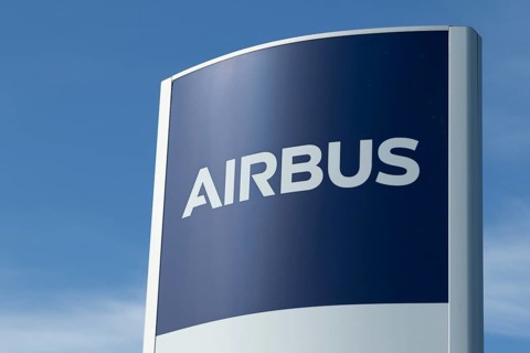 Close-up, sign with the logo against a blue sky at the entrance to the Airbus plant in